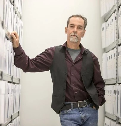 Jeff O'Brien leaning between shelves